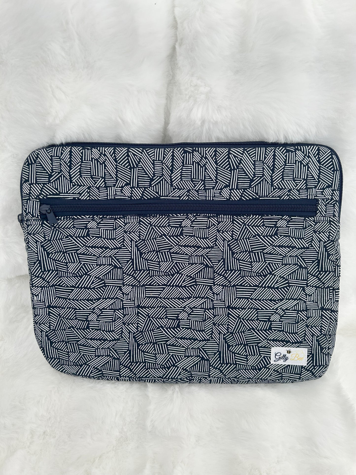 Navy Blue patterned laptop sleeve with a visible gilly bee brand label on a white background