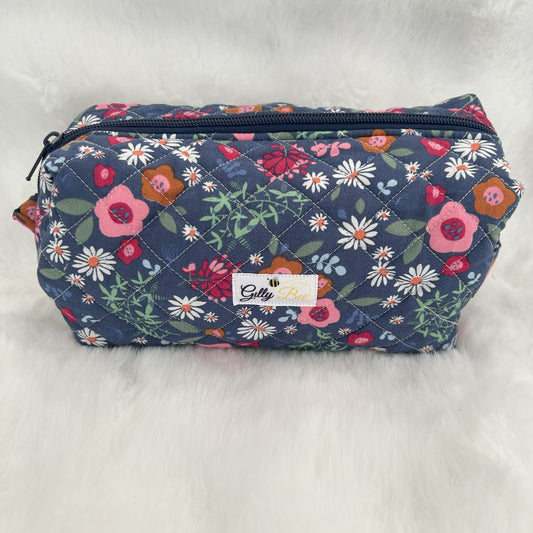 Floral-patterned quilted toiletry bag on a white background with a visible Gilly Bee brand label